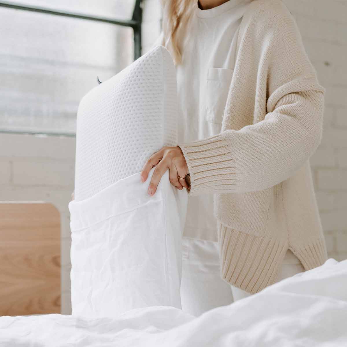 Woman putting Eva Pillow in a White Hemp Linen Pillowcase